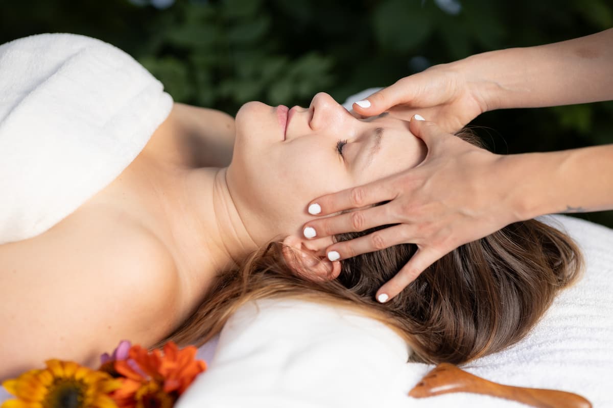 A képen egy nő arcát masszírozzák